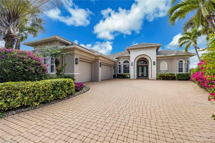 Mediterranean / spanish-style home with stucco siding, decorative driveway, french doors, and a garage
