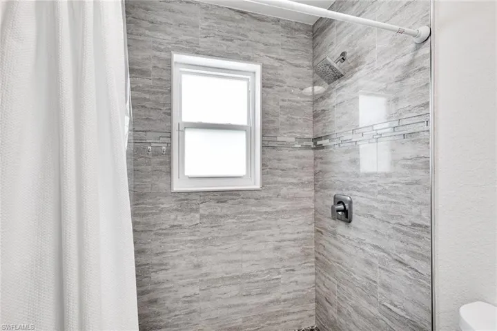 Full bath featuring tiled shower