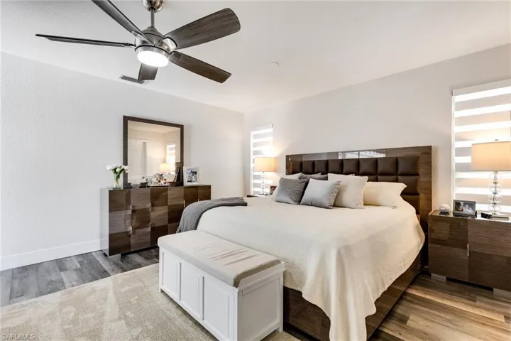 Bedroom featuring light wood-type flooring, baseboards, visible vents, and a ceiling fan