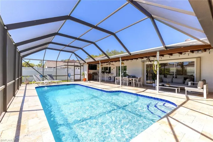 View of swimming pool with fence, glass enclosure, a fenced in pool, ceiling fan, and a patio area