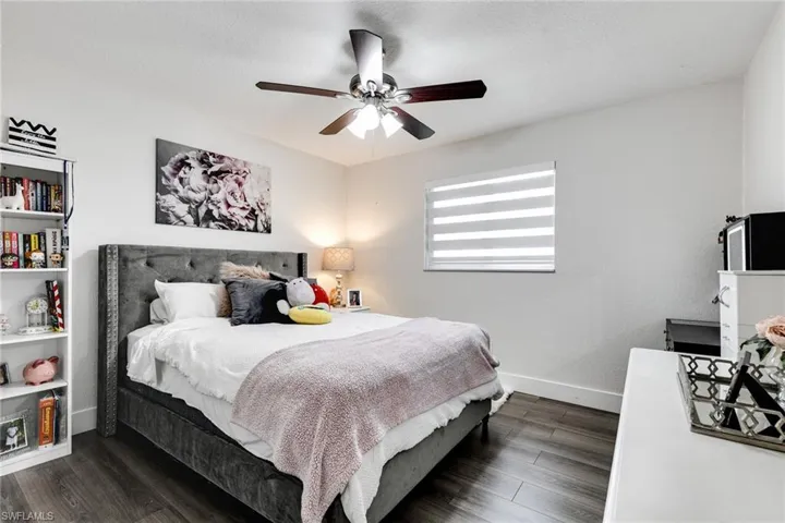 Bedroom featuring dark wood finished floors, a ceiling fan, baseboards, and a textured ceiling