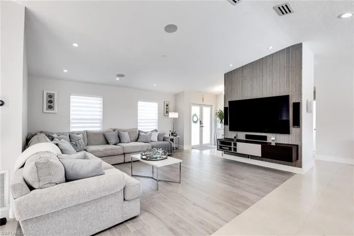 Living area featuring light wood-style flooring, recessed lighting, visible vents, and baseboards