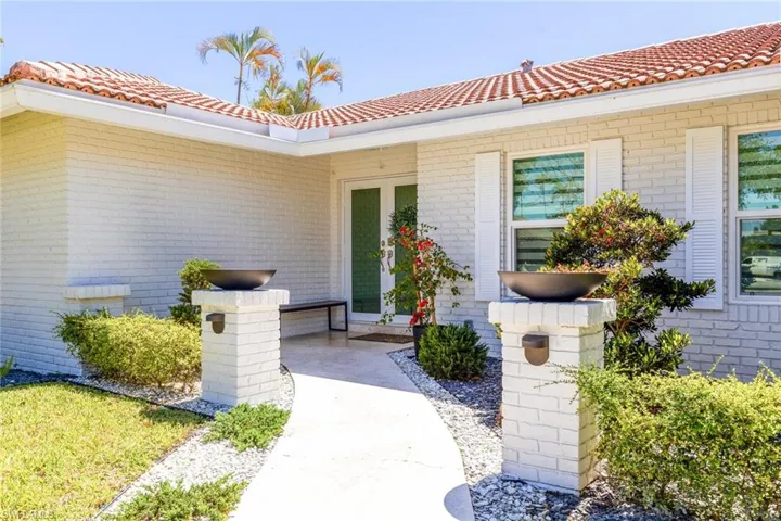 Property entrance with brick siding and a tile roof