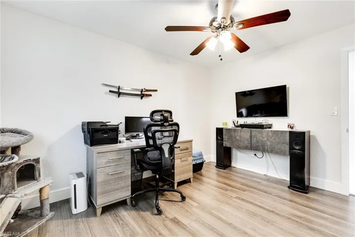 Office with baseboards, light wood-style floors, and ceiling fan