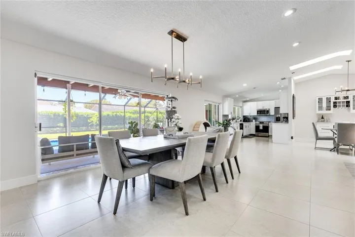 Dining area featuring a notable chandelier, plenty of natural light, and vaulted ceiling