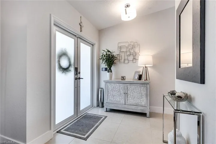 Foyer entrance featuring light tile patterned flooring and baseboards