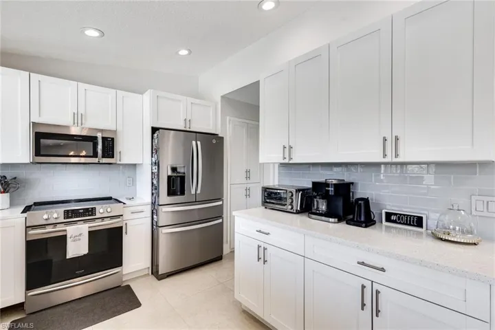Kitchen with appliances with stainless steel finishes and white cabinetry
