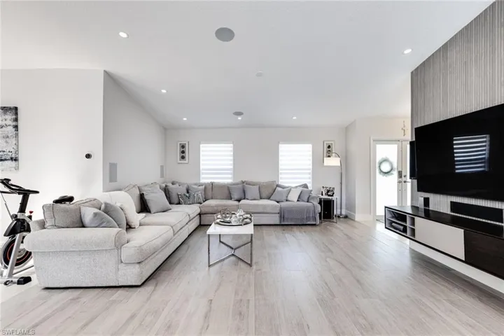 Living area with light wood-style flooring and recessed lighting