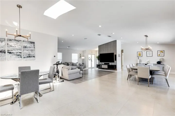 Dining room with a chandelier, light tile patterned floors, recessed lighting, and lofted ceiling