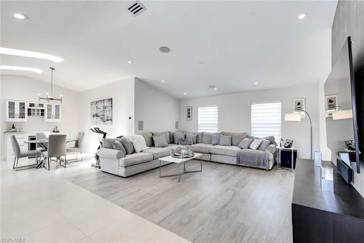 Living area featuring visible vents, a notable chandelier, recessed lighting, light tile patterned flooring, and vaulted ceiling