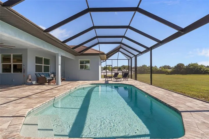 Swimming pool featuring a sunroom, a patio, a yard, a lanai, and ceiling fan