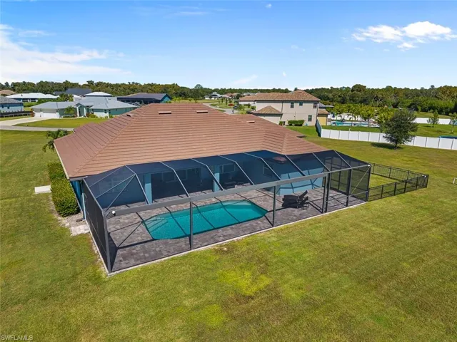 Swimming pool with a lanai, a yard, a residential view, and a sunroom