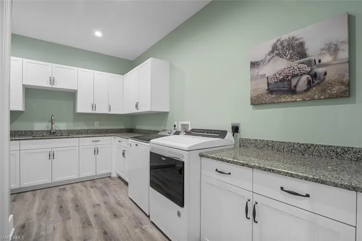 Washroom featuring cabinet space, light wood-style floors, recessed lighting, and independent washer and dryer