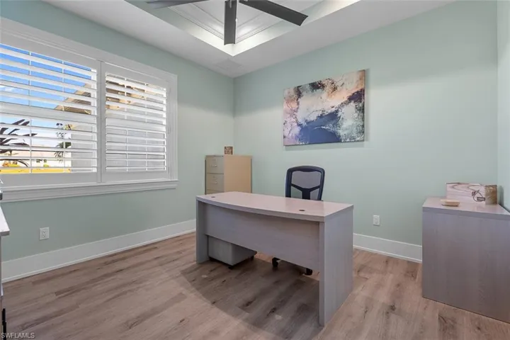 Office space with light wood-type flooring and a ceiling fan