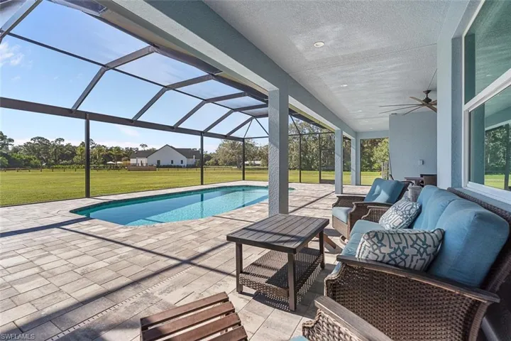 Swimming pool featuring a yard, a sunroom, a lanai, a patio, and ceiling fan