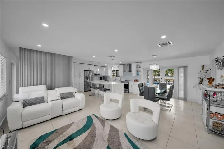 Living room with recessed lighting, light tile patterned floors, and visible vents