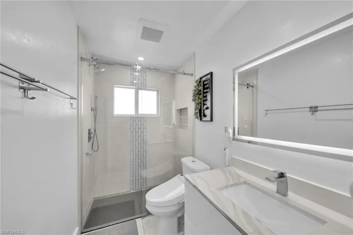Full bath featuring toilet, a stall shower, and vanity