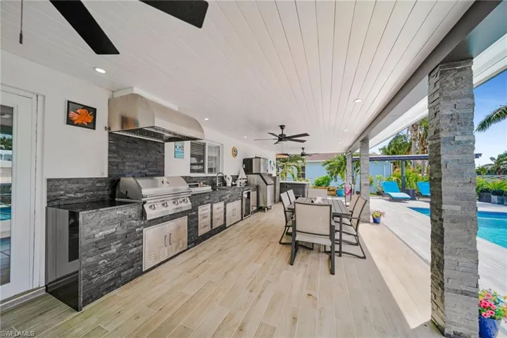 View of patio / terrace with a grill, a ceiling fan, area for grilling, outdoor dining space, and an outdoor pool