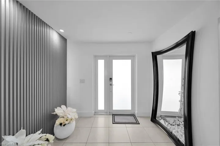 Foyer entrance with light tile patterned floors, baseboards, and recessed lighting