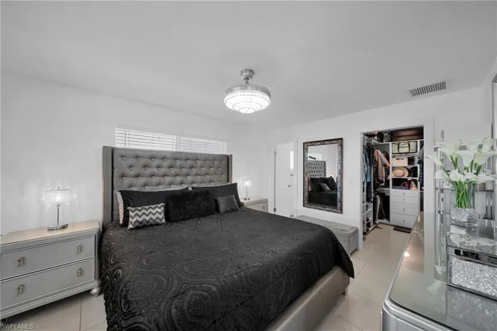 Bedroom featuring a walk in closet, a closet, light tile patterned flooring, and visible vents