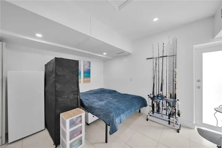 Tiled bedroom featuring recessed lighting and fridge