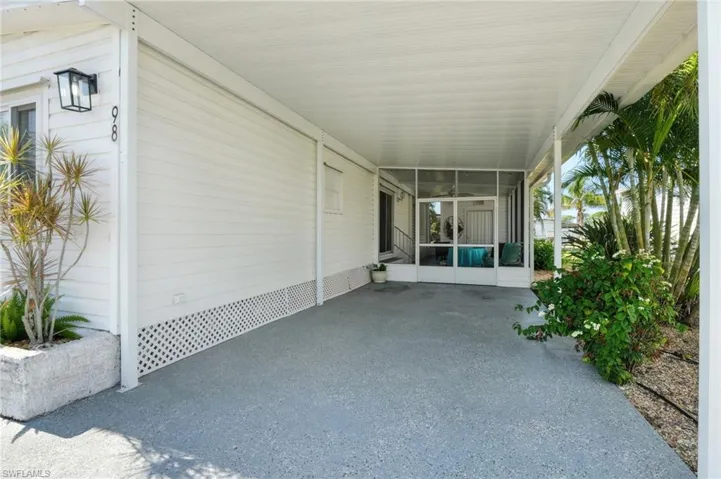 View of patio / terrace featuring a sunroom and a carport