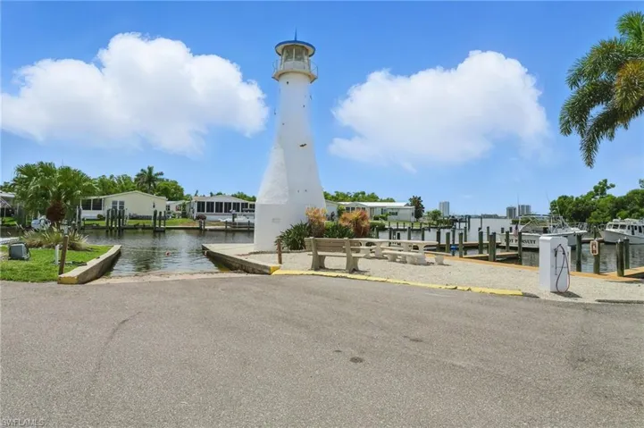 View of community with a dock, a boat ramp, and a water view