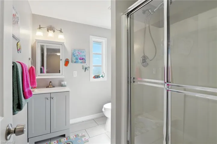 Full bathroom with tile patterned flooring, vanity, and a stall shower