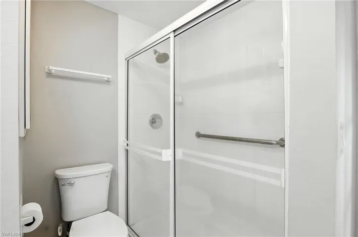Full bath featuring toilet and a stall shower located within the Owners Suite