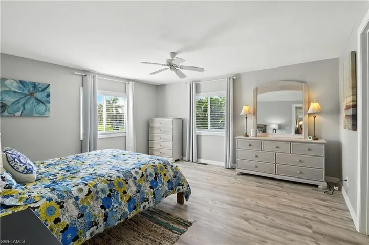 Owners Suite, a huge space with light wood finished floors and a ceiling fan