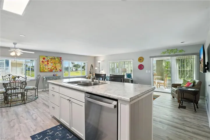 Kitchen featuring dishwasher, light countertops, white cabinetry, and light wood-style flooring