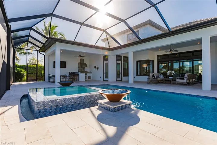 View of swimming pool featuring ceiling fan, a lanai, and a patio area