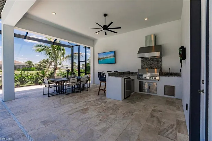 View of patio with exterior kitchen, grilling area, sink, and ceiling fan