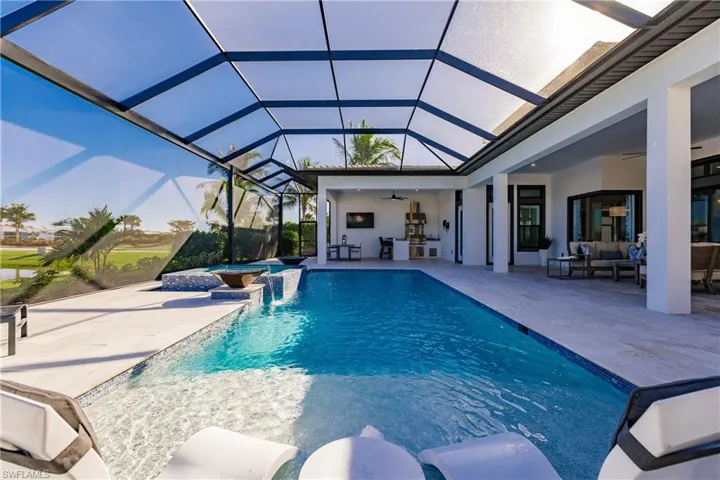 View of swimming pool with an in ground hot tub, pool water feature, a lanai, a patio area, and ceiling fan
