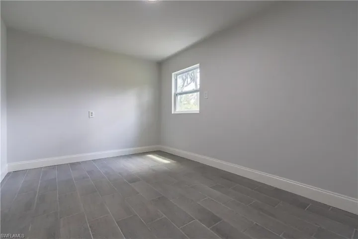 Spare room featuring dark wood-type flooring