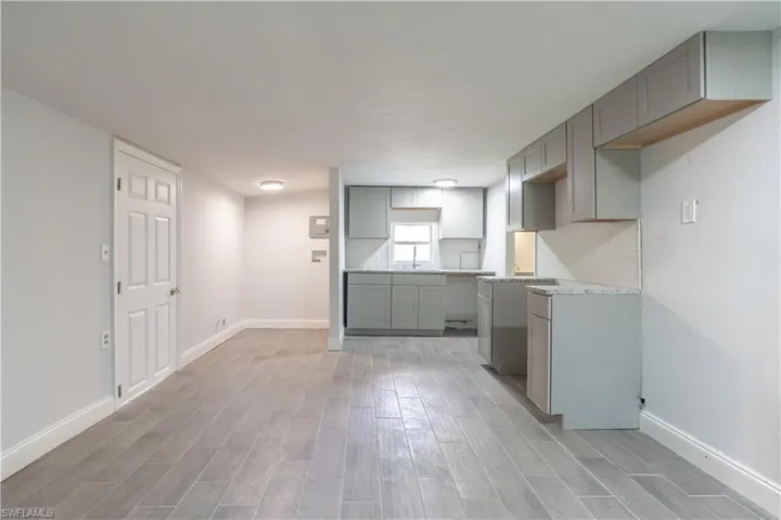 Kitchen with light hardwood / wood-style floors and gray cabinetry