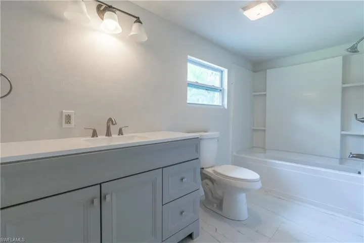 Full bathroom featuring vanity, bathing tub / shower combination, and toilet