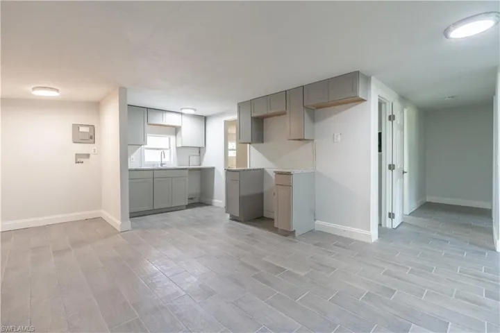 Kitchen featuring gray cabinetry, sink, and light wood-type flooring