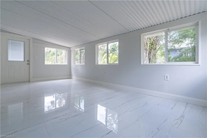 Empty room featuring a wealth of natural light and lofted ceiling