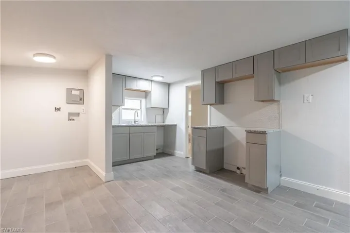 Kitchen with gray cabinetry, sink, and light hardwood / wood-style flooring