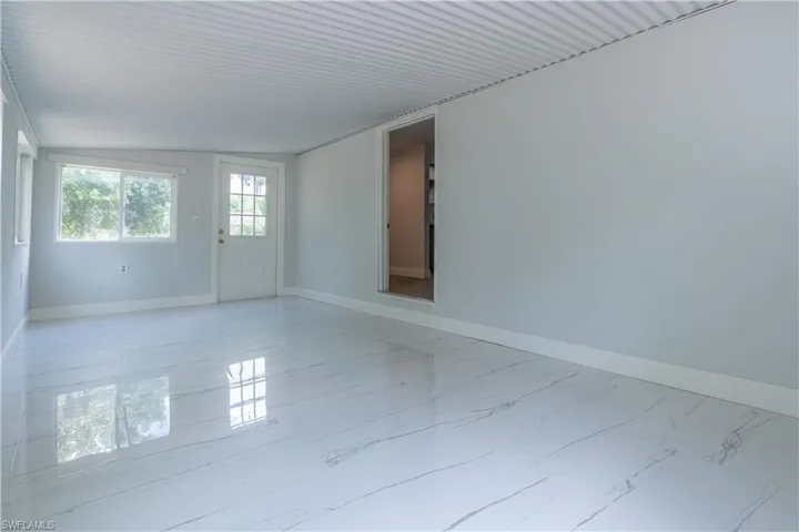 Empty room featuring vaulted ceiling