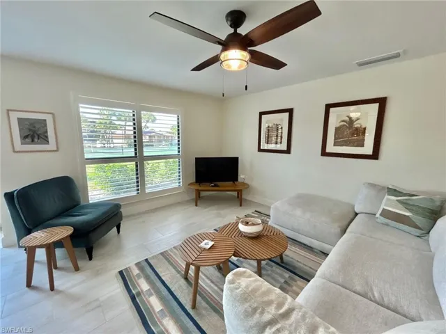 Living room featuring a ceiling fan and baseboards