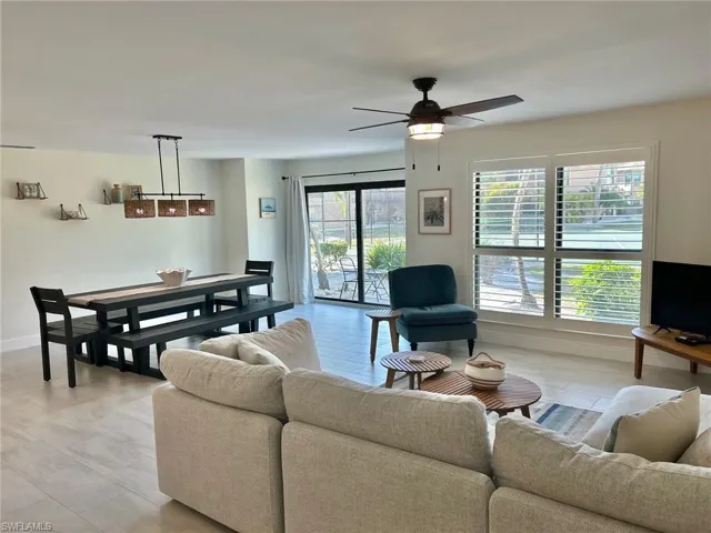 Living room featuring ceiling fan and baseboards
