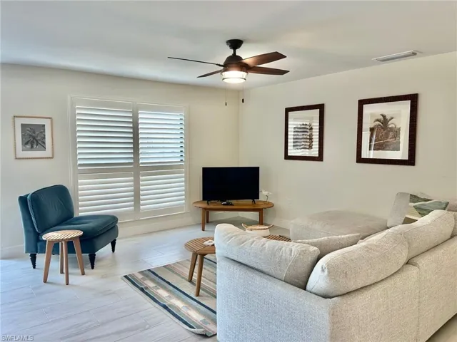 Living area with ceiling fan and baseboards