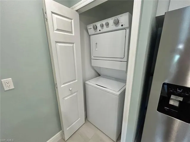 Laundry area featuring stacked washer / drying machine and baseboards