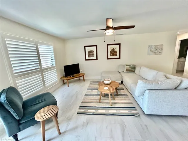 Living area featuring light flooring and ceiling fan