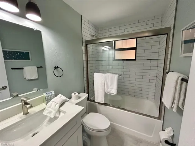 Primary bathroom with vanity and enclosed tub / shower combo