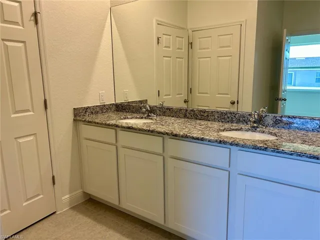 Bathroom with double vanity and tile patterned floors