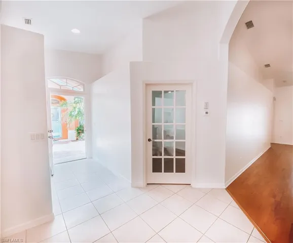 Hall featuring lofted ceiling and light tile floors