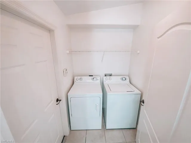 Laundry room featuring washer and dryer, hookup for a washing machine, and light tile floors